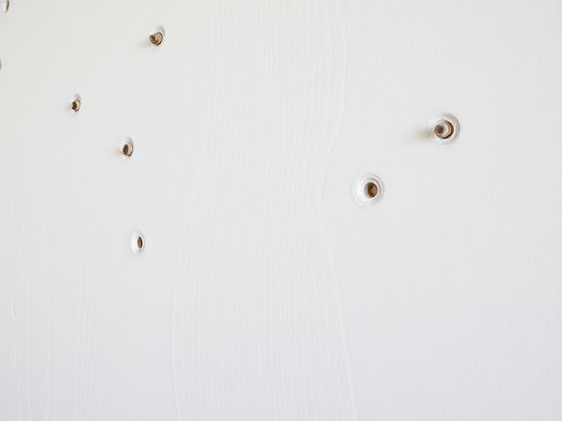 Nahaufnahme Bohrlöcher in weißer Wand